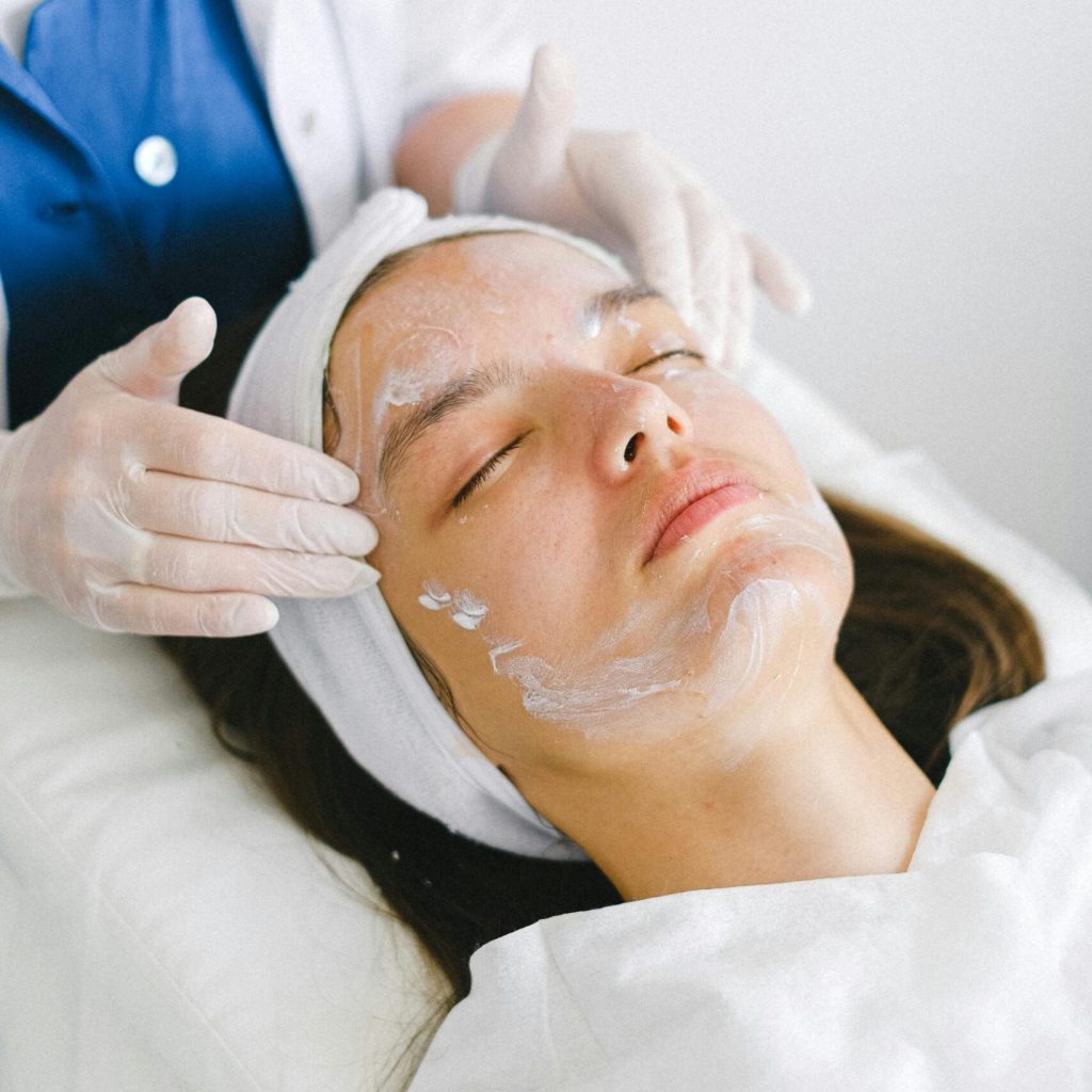 Woman receiving a facial treatment at a spa, promoting skin health and relaxation.