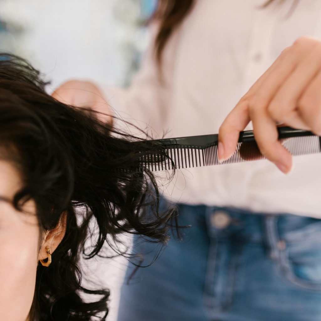 Close-up of hairstylist cutting client's hair in a salon setting.
